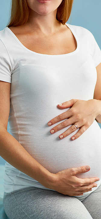 Schwangere Frau Schwangere Frau, die die Hände auf den Bauch gelegt hat und mit ihrem Frauenarzt spricht