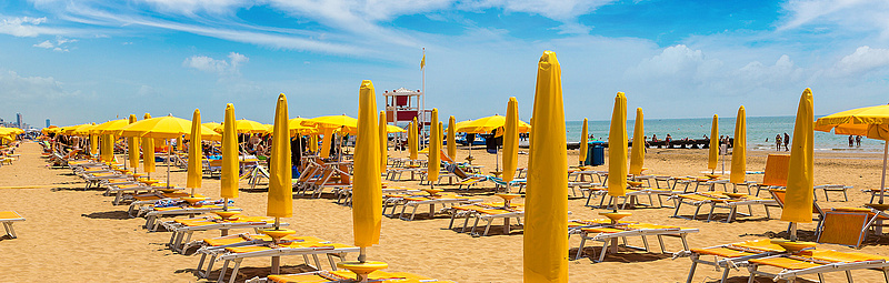 Strand mit gelben Schirmen - Sergii Figurnyi/adobe.stock.com