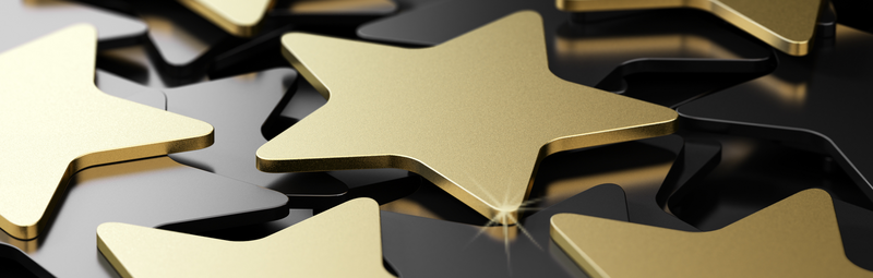Goldene Sterne liegen auf schwarzem Hintergrund
