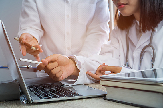 Mediziner*innen vor Laptop