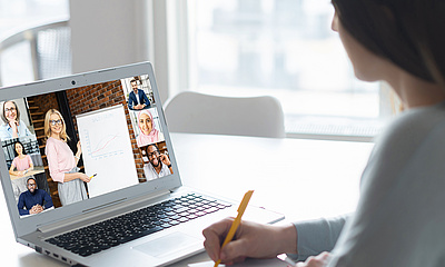 Frau, die mit einem Laptop an einem Online-Kurs oder Webinar teilnimmt. 