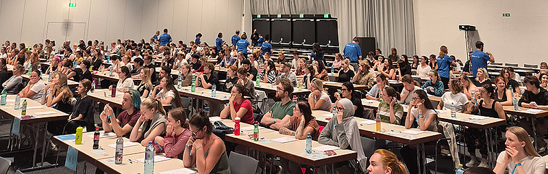Die Studienwerber*innen für das Psychotherapiestudium sitzen in der Grazer Stadthalle und warten auf den Start des Tests.