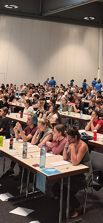 Die Studienwerber*innen für das Psychotherapiestudium sitzen in der Grazer Stadthalle und warten auf den Start des Tests.