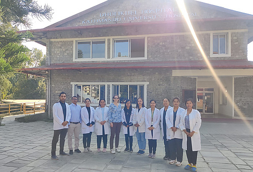 Iva Brcic and local doctors and students in front of the Dhulikhel Hospital teaching hospital of the Kathmandu University School of Medical Sciences