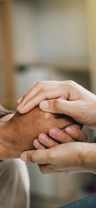 Ein Psychiater hält die Hände eines Patienten fest
