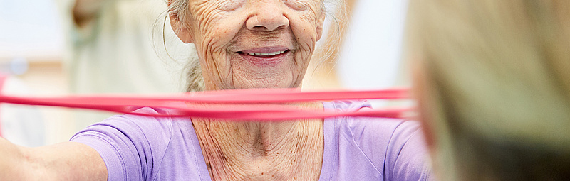 Seniorin bei Gymnastik mi Theraband