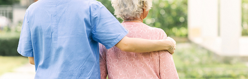 Eine Pflegerin begleitet eine ältere Frau