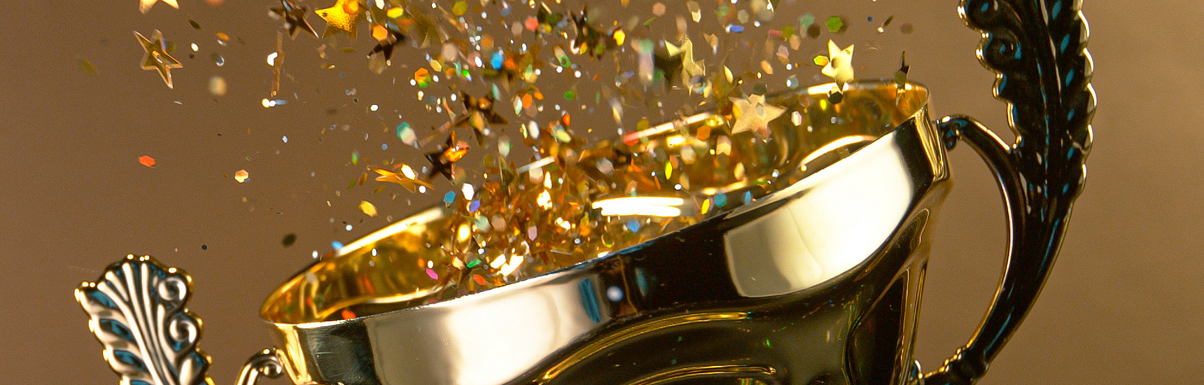 Ein Pokal aus dem Confetti sprüht auf goldenem Hintergrund